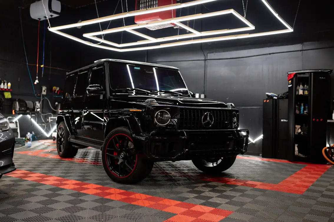 Black Mercedes-AMG G63 with red-accent wheels and full clear paint protection film.